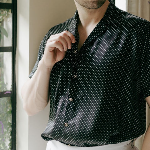 close up photo of a short sleeve black dotted silk shirt from 1000 kingdoms being worn by a model