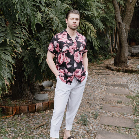 model standing in a garden wearing a short sleeve black and pink silk shirt from 1000 kingdoms